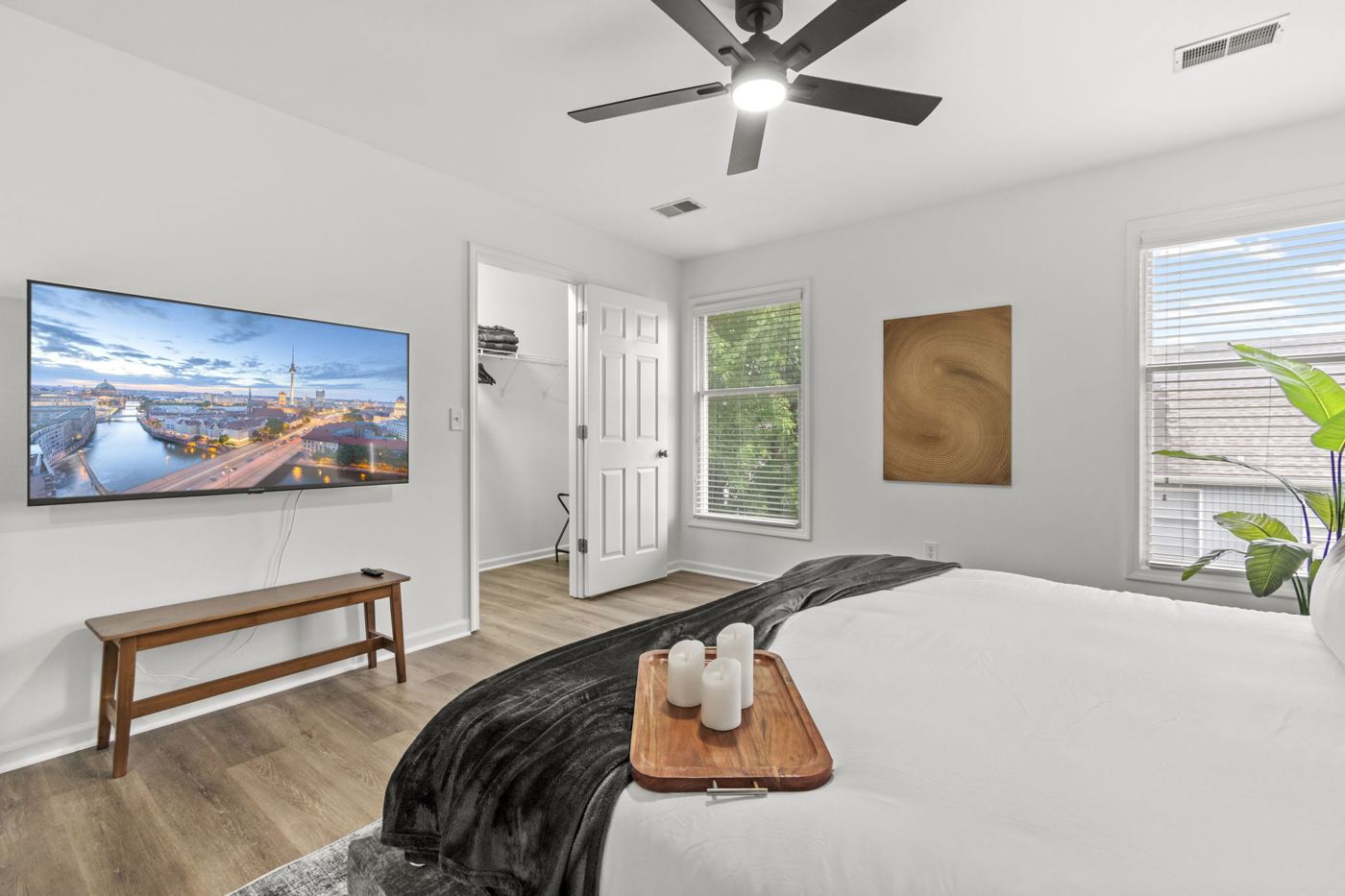Primary suite with wall-mounted TV and bench