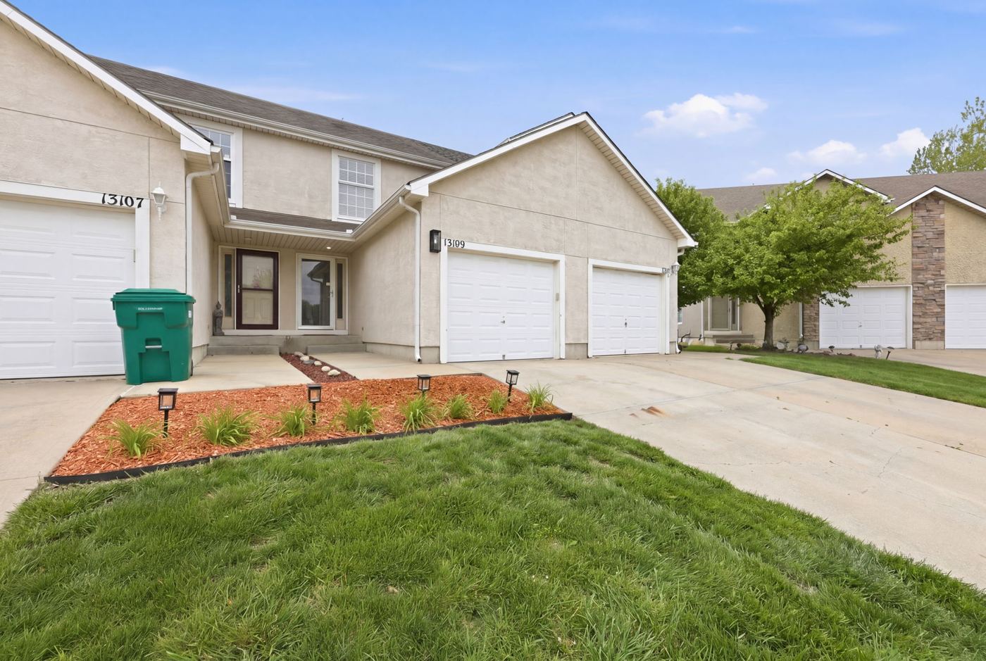 Front of the home with garage, driveway and landscaped bed