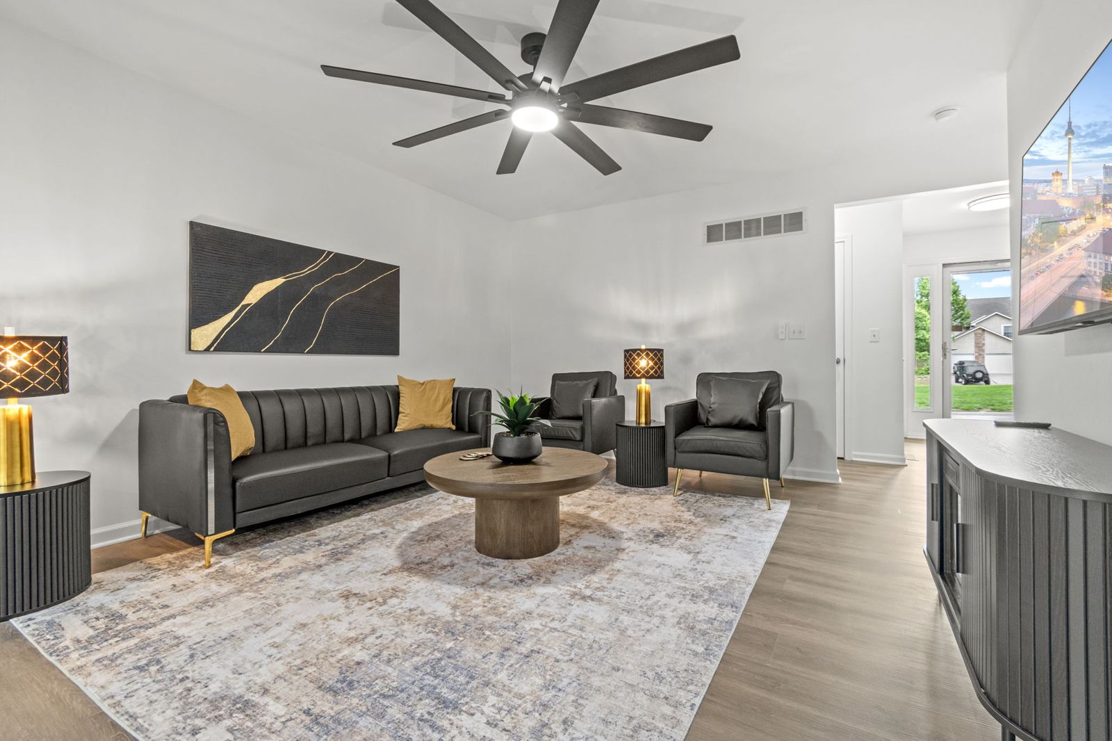 Main living area with leather sofa and ceiling fan
